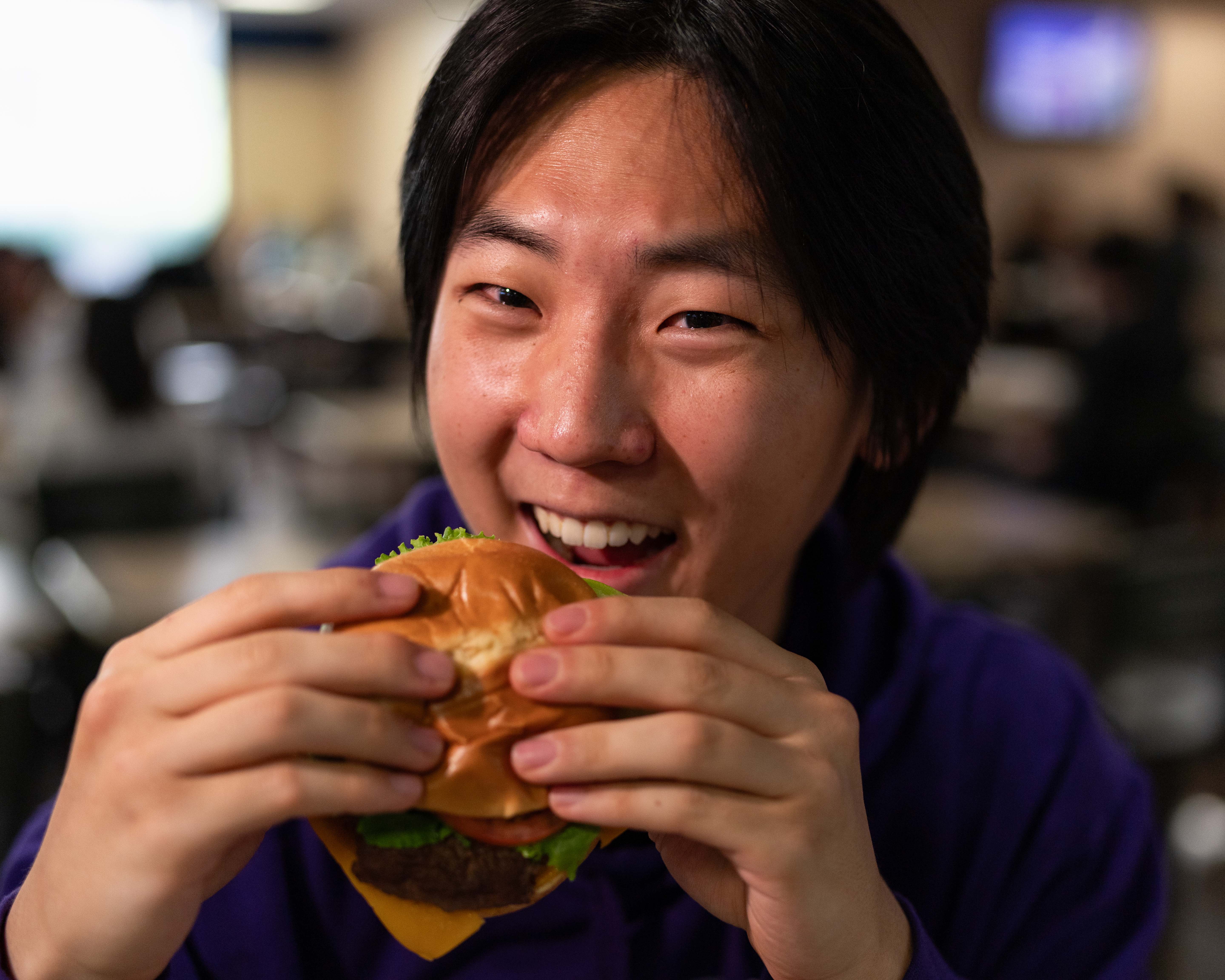 A student eating a burger.