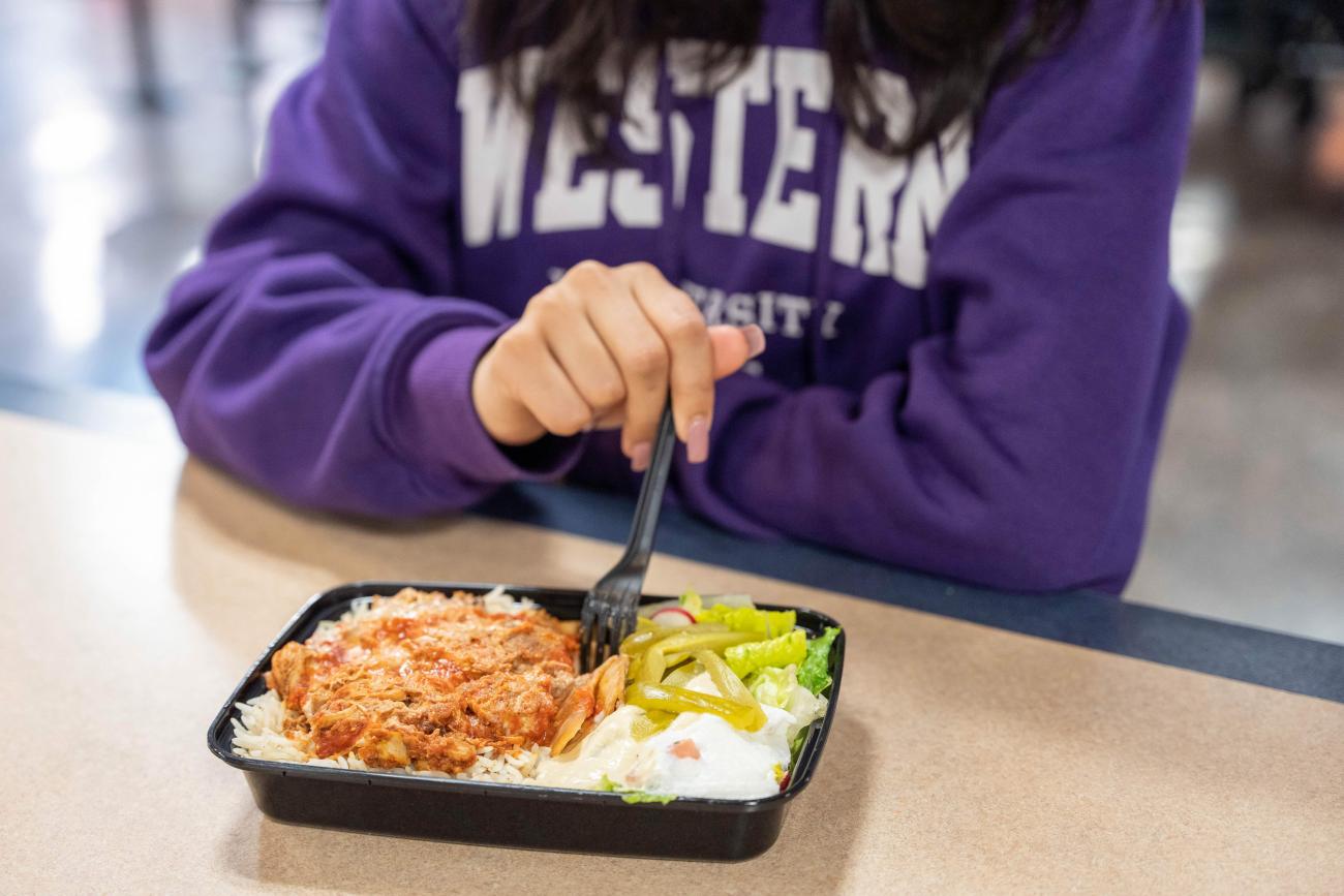 A student eating a chicken bowl