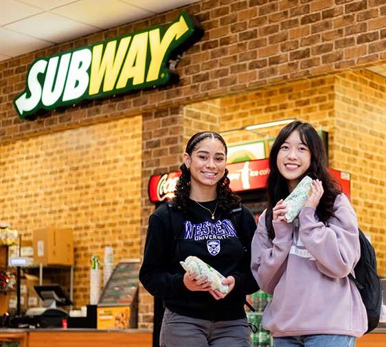 Student standing in front of subway