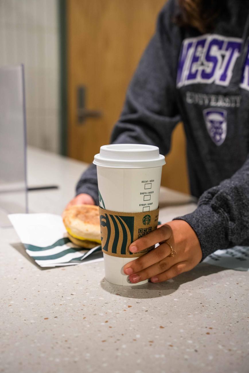 A student grabbing a Starbucks order