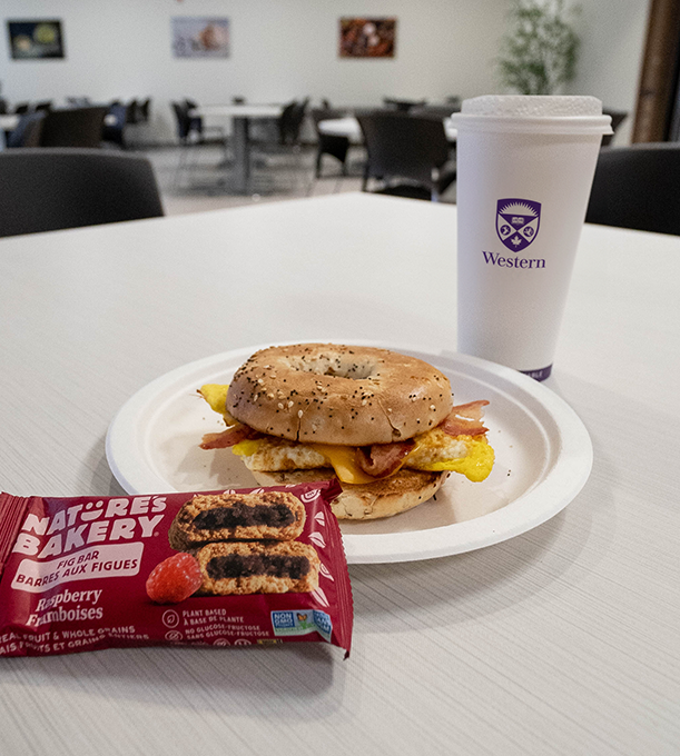 A breakfast sandwich, coffee and snack