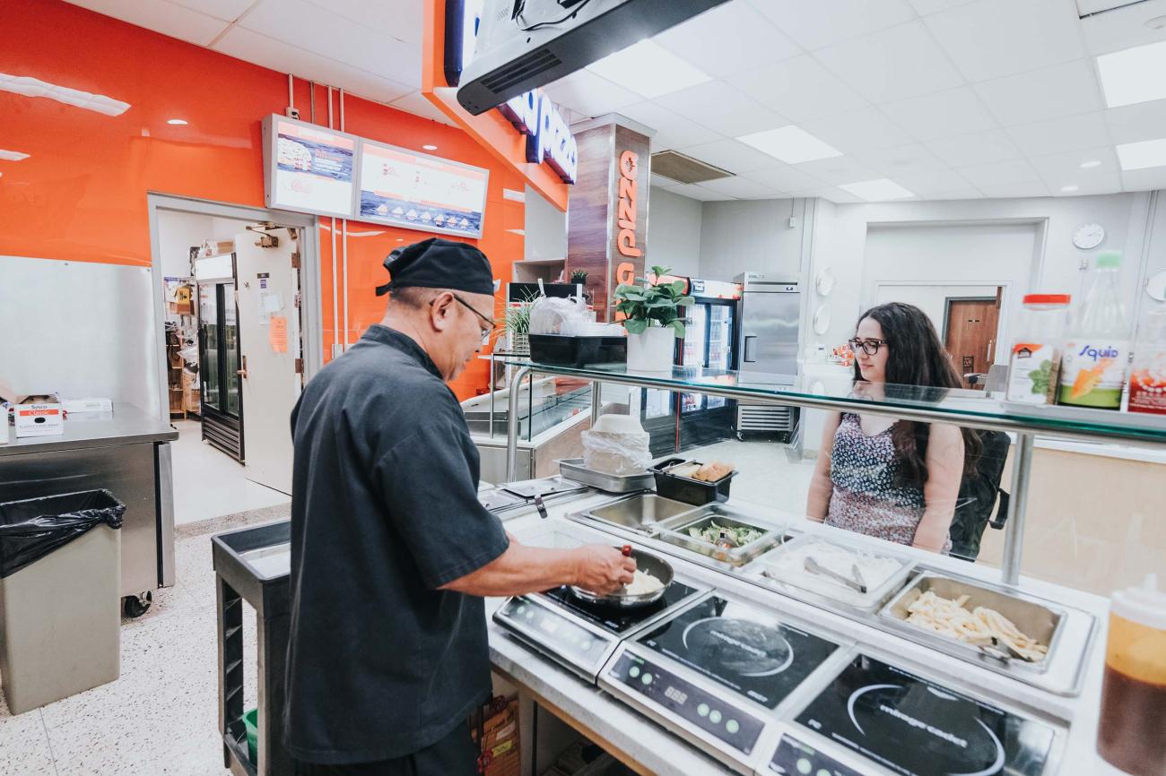 A student ordering food from Noodles